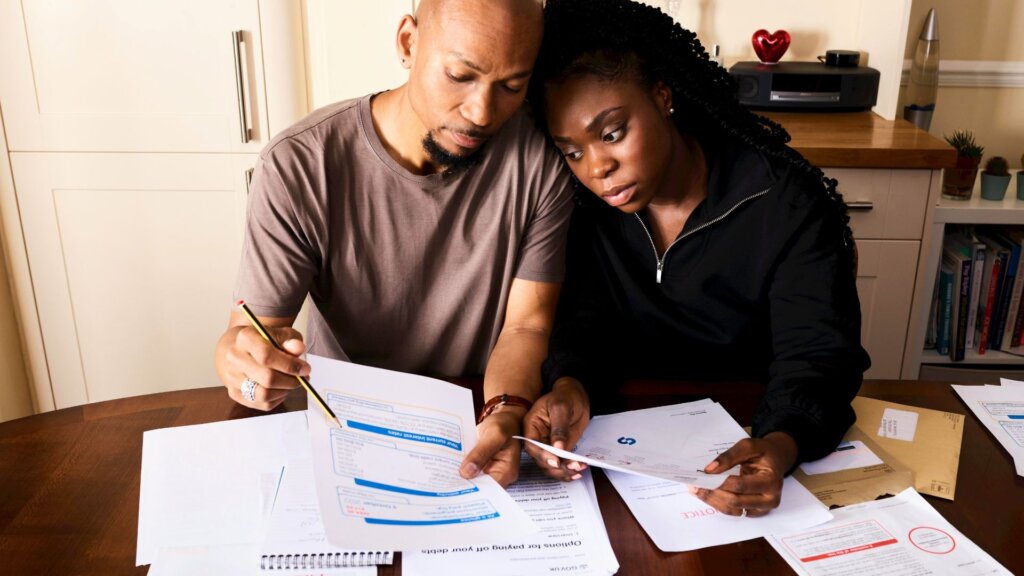 Stressed homeowners going over monthly bills at the kitchen table