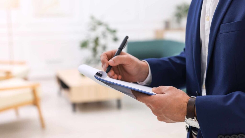 Real estate professional writing notes on clipboard