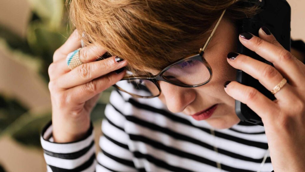 Woman looking stressed while talking on phone
