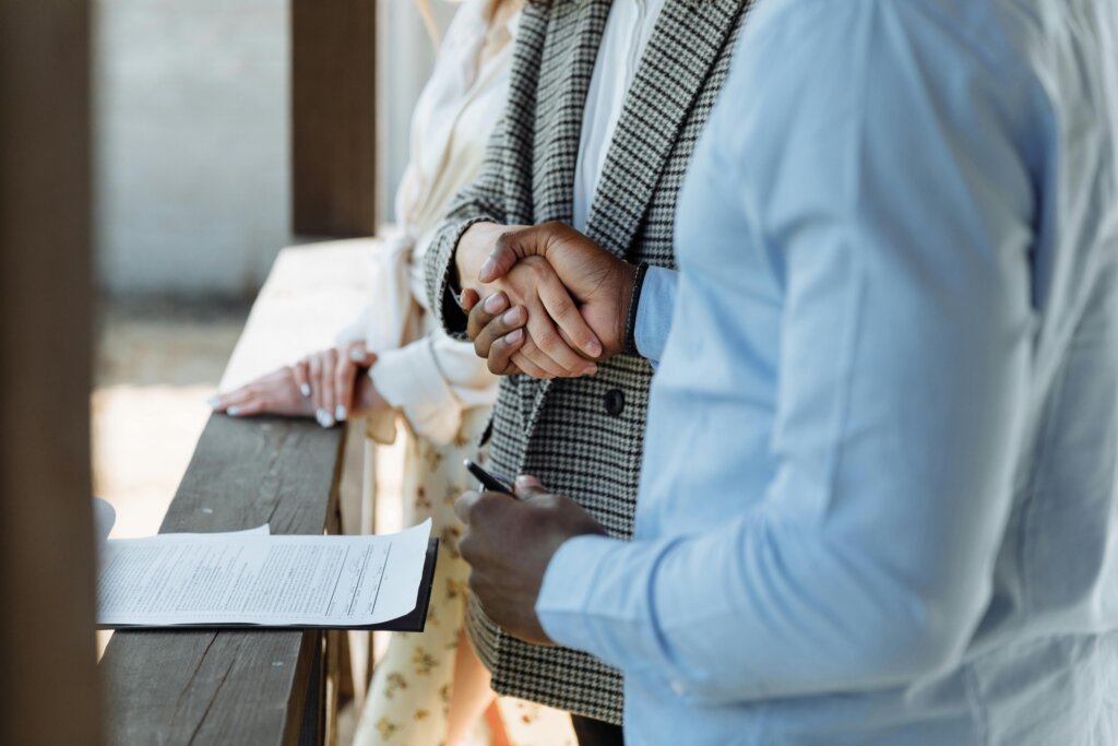 Two people shaking hands during home sale discussion